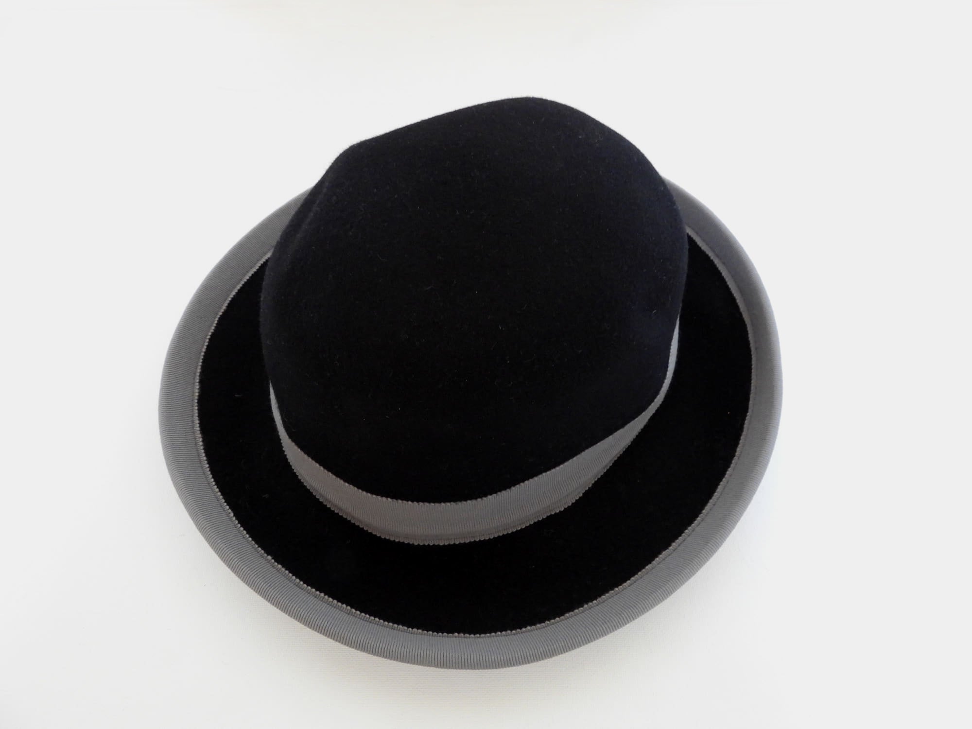 Felted bowler style black hat with grey grosgrain hatband and brim binding. Wear it bowler style with the brim up or turn the brim down for a bit of sass. Made in Denmark for Andersen &amp; Berner. 1980s??