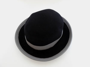 Felted bowler style black hat with grey grosgrain hatband and brim binding. Wear it bowler style with the brim up or turn the brim down for a bit of sass. Made in Denmark for Andersen &amp; Berner. 1980s??